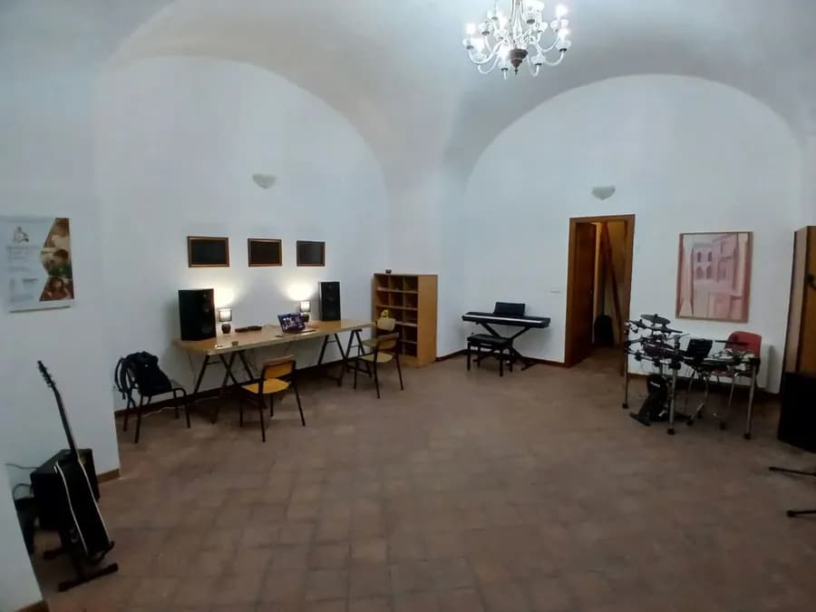 Sala prove della scuola con pianoforte digitale, batteria elettronica e chitarra