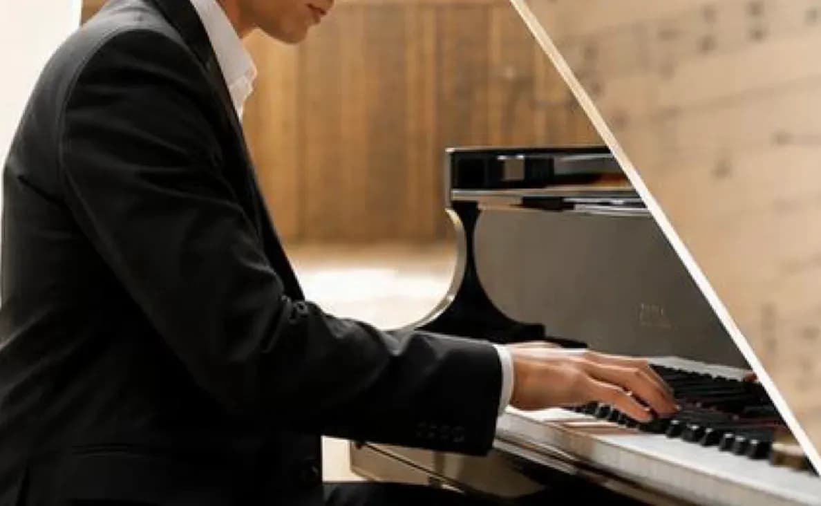 Mani del pianista sulla tastiera del pianoforte a coda